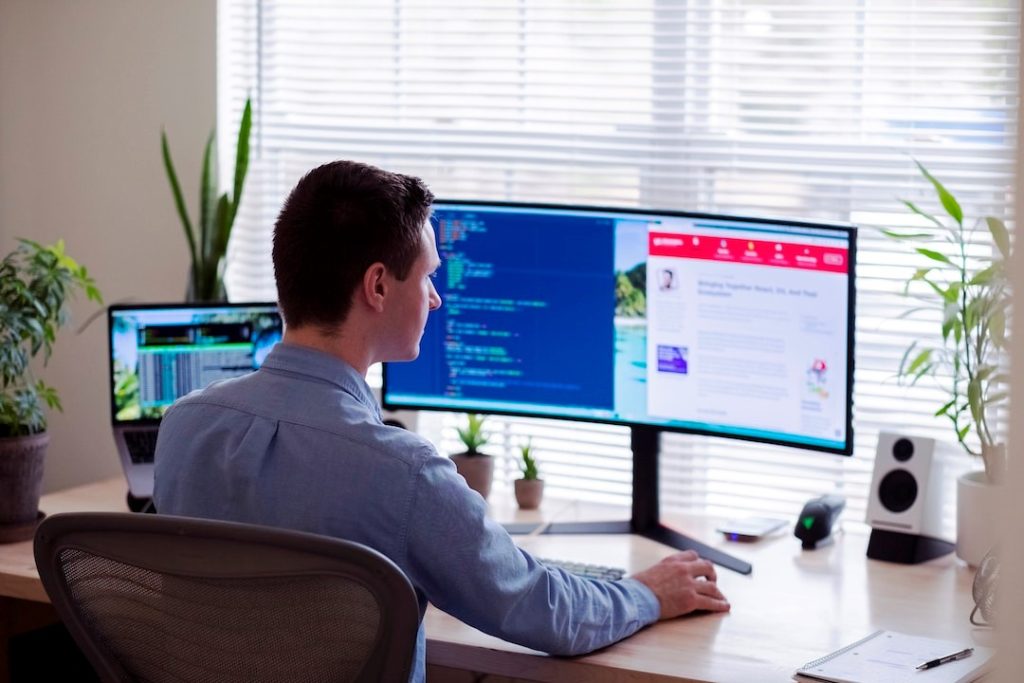 A person on a computer at a desk in front of a window, implementing an enterprise search solution.